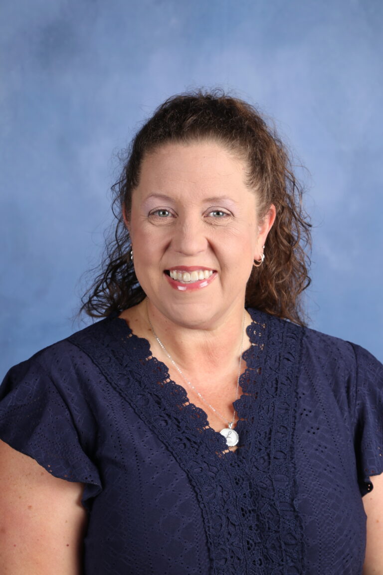 Tetyana Horoian, smiling woman with curly hair against a blue background.