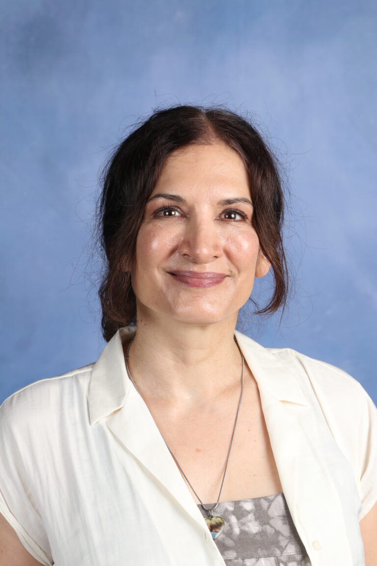 Tetyana Horoian portrait, smiling woman with dark hair and a white blouse.
