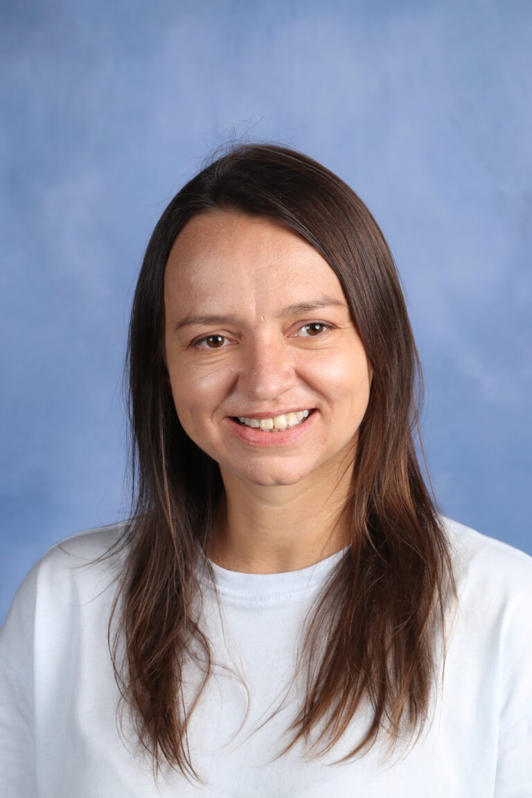 Tetyana Horoian, smiling with brown hair against a blue background.