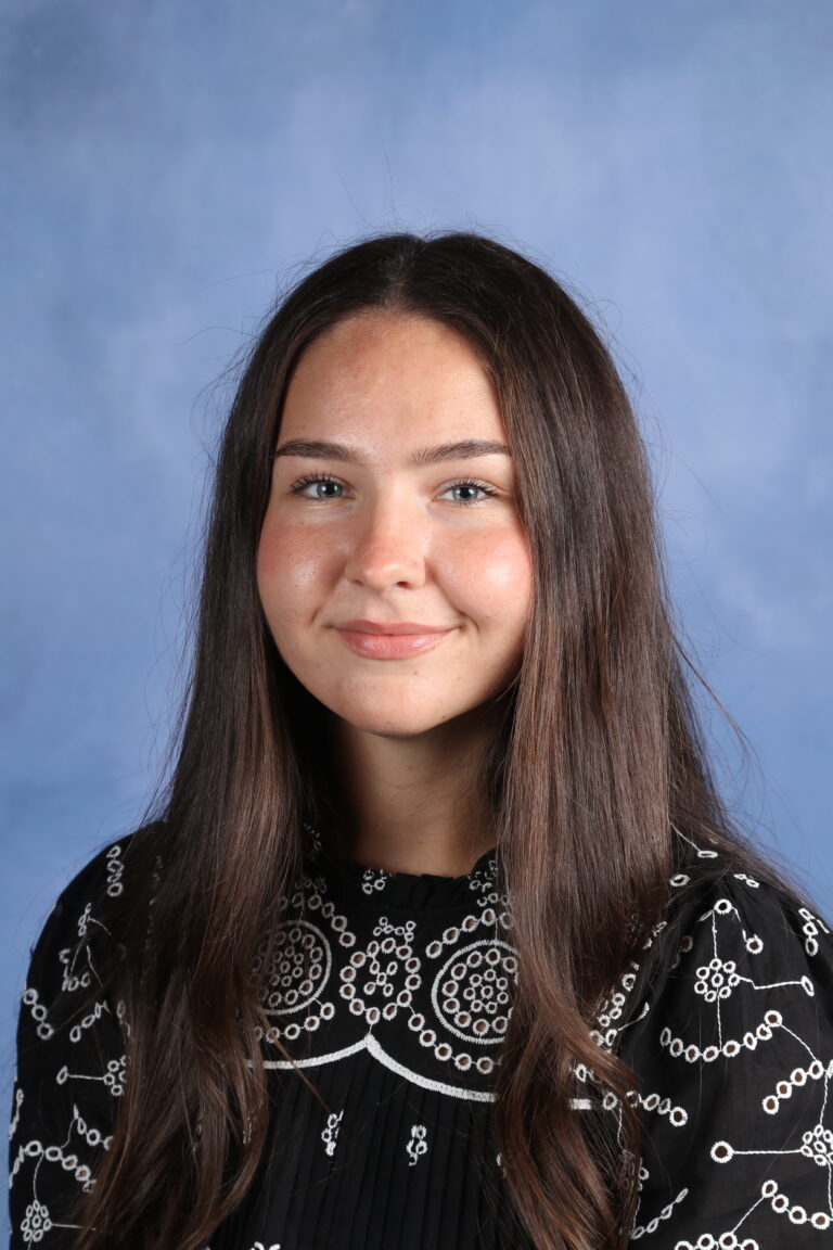 Tetyana Horoian portrait with long brown hair and a patterned black top.