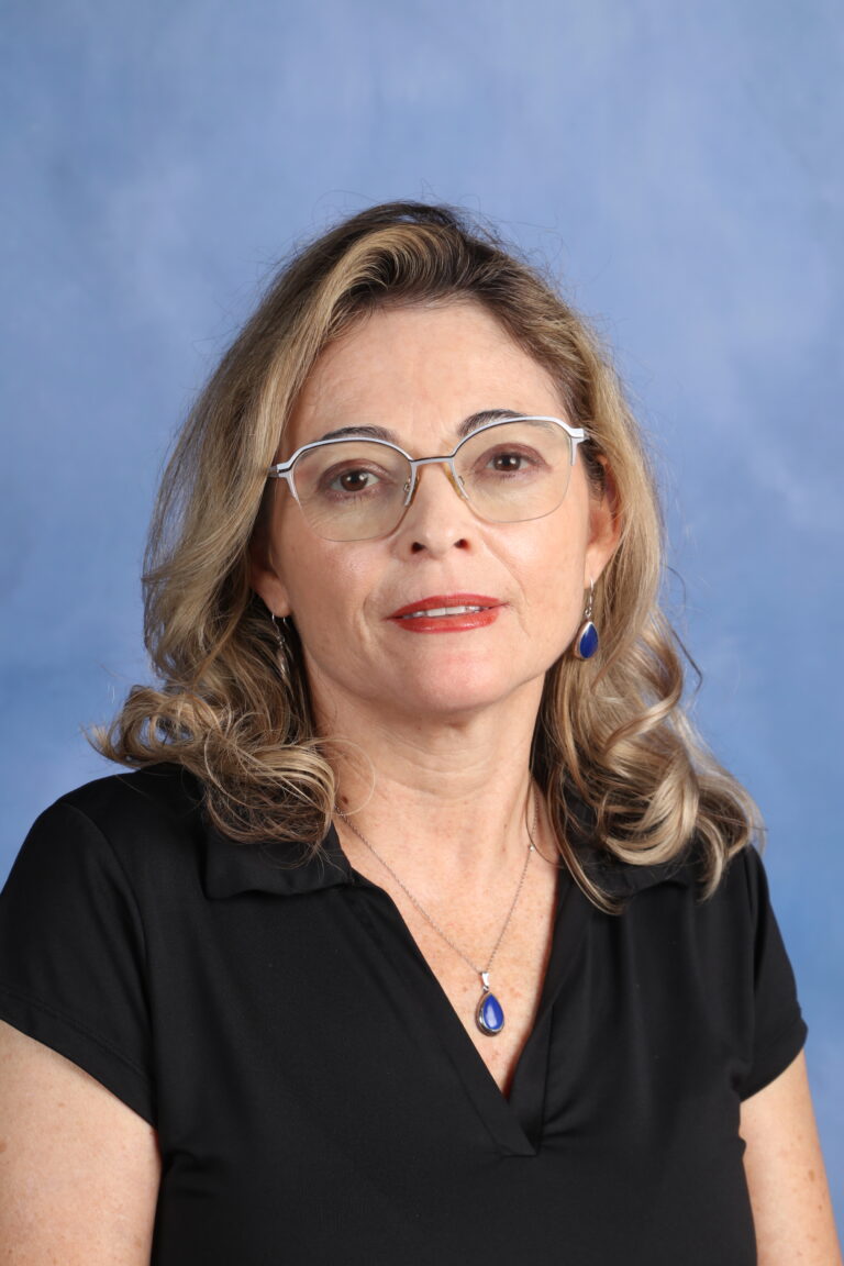 Portrait of Tetyana Horoian, wearing glasses and a black top, against a blue background.