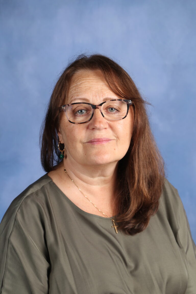 Tetyana Horoian portrait, wearing glasses and a green top, against a blue background.
