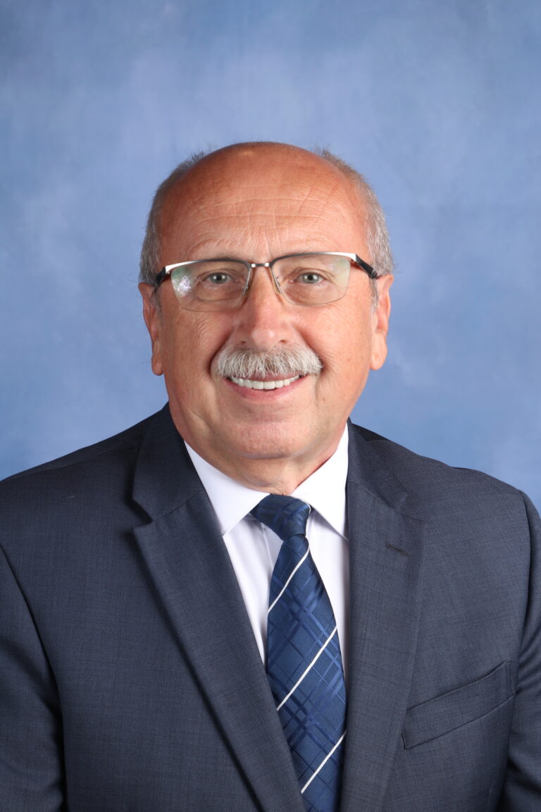 Professional headshot of Tetyana Horoian, wearing a suit and tie against a blue background.