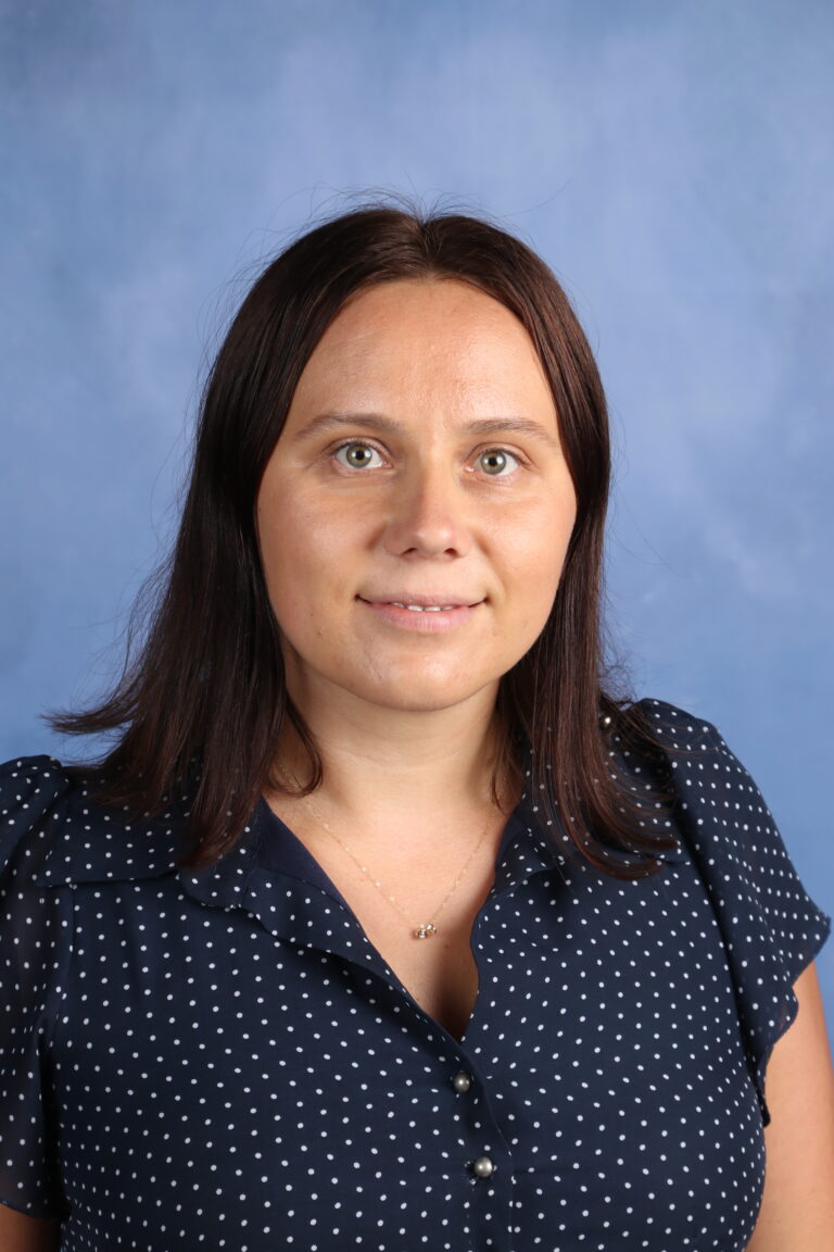 Portrait of Olha Olekshenko, wearing a polka-dot shirt and a gold necklace.