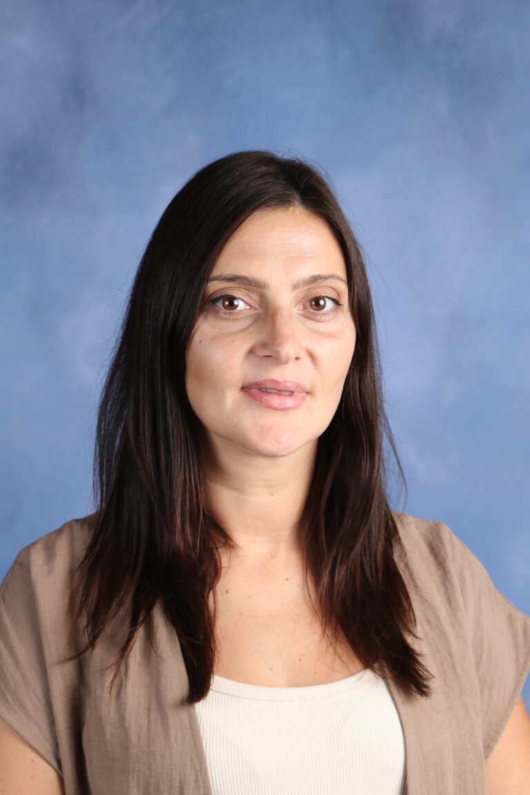 Portrait of Anastasiia Halytsia, a woman with dark hair, against a blue backdrop.