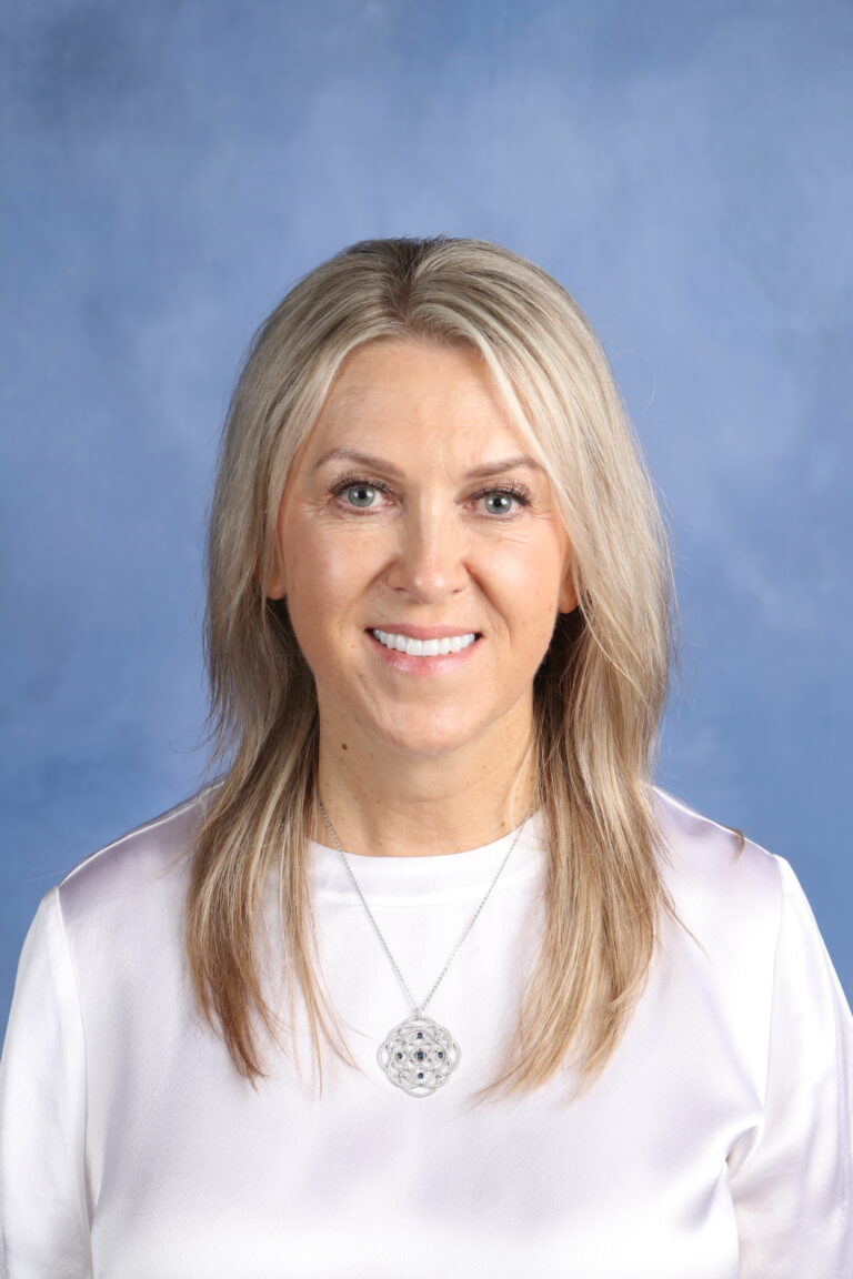 Portrait of Alla Rudishina, smiling with blonde hair and a silver pendant.