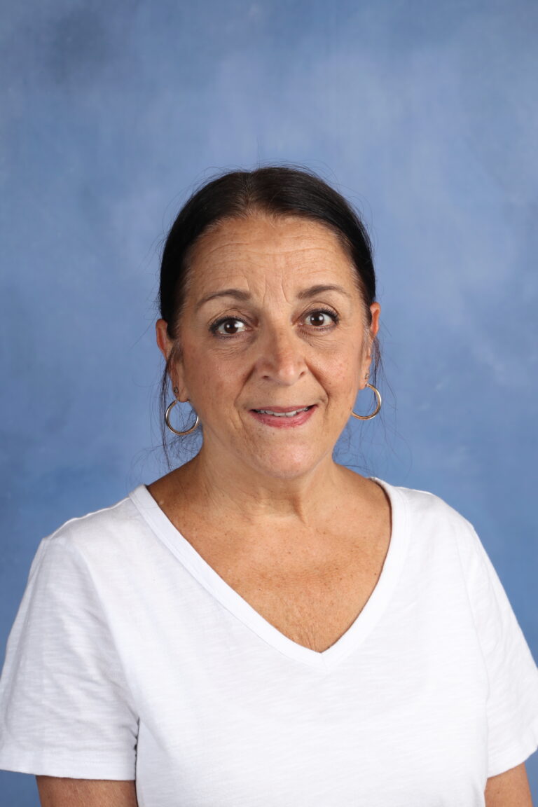Denise Homan portrait, smiling against a blue background.
