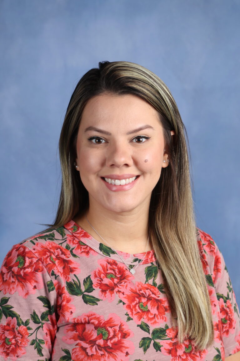 Fernanda Martins portrait; woman with blonde highlights smiling in floral top.
